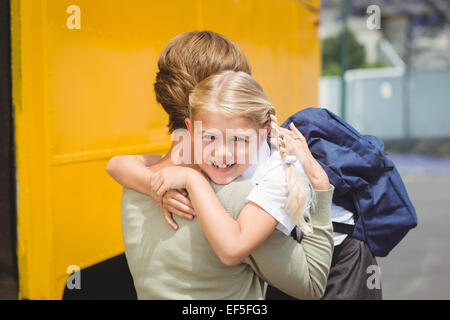Mother hugging her daughter by school bus Stock Photo - Alamy