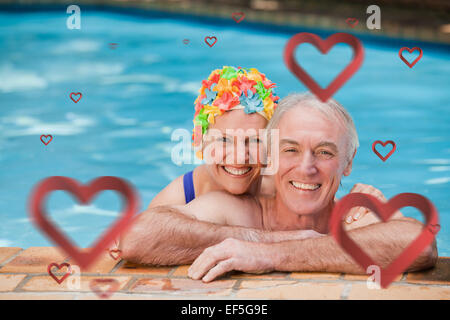 Composite image of happy mature couple in the swimming pool Stock Photo