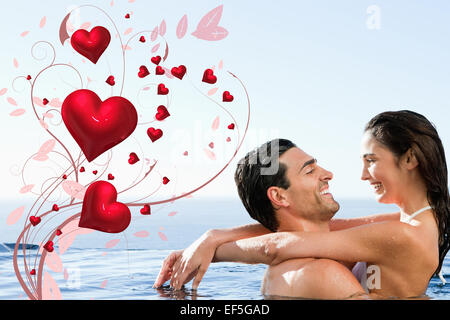 Composite image of couple embracing in the pool Stock Photo