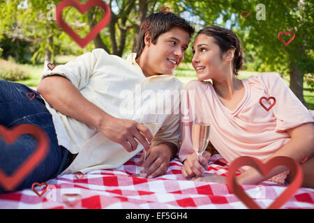 Composite image of two friends looking at each other while having a picnic Stock Photo