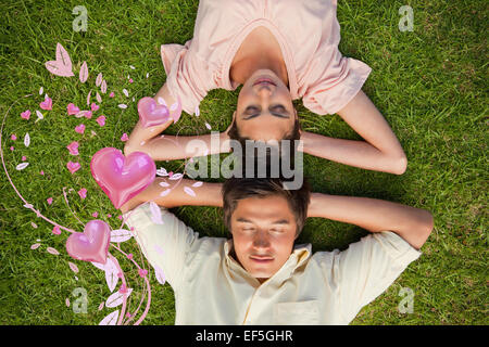 Composite image of woman and a man lying head to head with both hands behind their neck Stock Photo