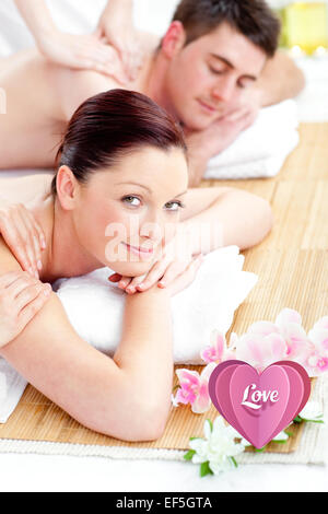 Composite image of relaxed young couple receiving a back massage Stock Photo
