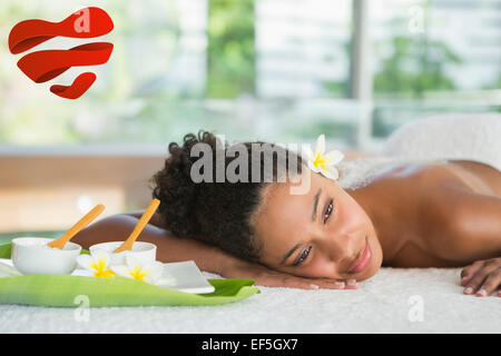 Composite image of gorgeous woman lying on massage table with salt treatment on back Stock Photo