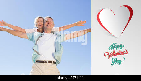 Composite image of happy senior man giving his partner a piggy back Stock Photo