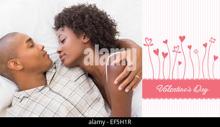 Composite image of happy couple sleeping in bed together Stock Photo