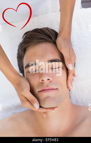 Composite image of man receiving facial massage at spa center Stock Photo