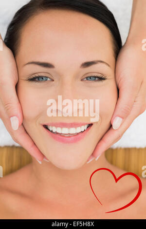 Composite image of peaceful brunette enjoying a facial massage Stock Photo