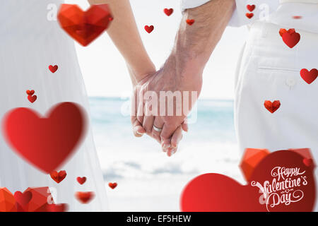 Composite image of bride and groom holding hands close up Stock Photo