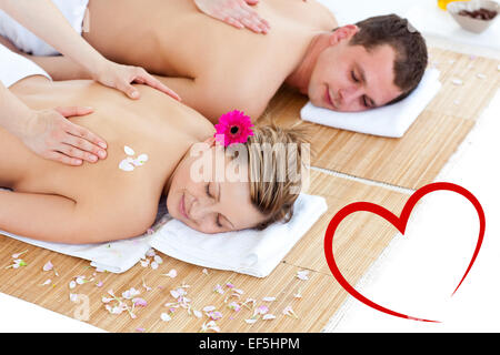 Composite image of beautiful young couple receiving a back massage Stock Photo