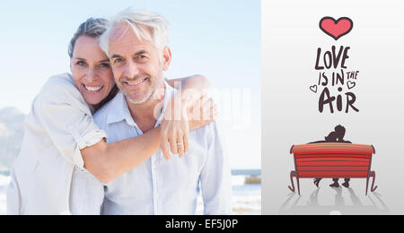 Composite image of attractive married couple posing at the beach Stock Photo