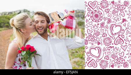 Composite image of cute couple going for a picnic with woman kissing boyfriends cheek Stock Photo