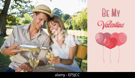 Composite image of cute couple drinking white wine together outside Stock Photo