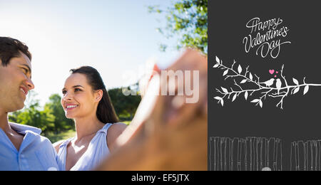 Composite image of loving and happy couple dancing at park Stock Photo