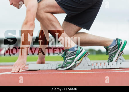Composite image of side view of a man ready to race on running trac Stock Photo