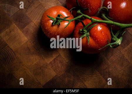 Wet tomatoes on a chopping board Stock Photo