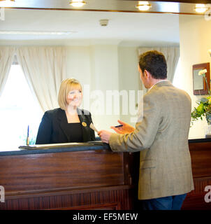 A man checking into a hotel reception Stock Photo