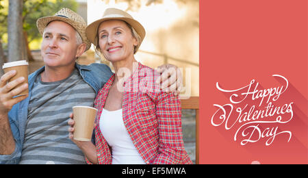 Composite image of happy mature couple drinking coffee on a bench in the city Stock Photo