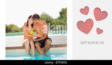 Composite image of gorgeous couple sitting poolside on holidays Stock Photo
