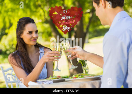 Composite image of couple toasting champagne flutes at an outdoor cafÃ© Stock Photo