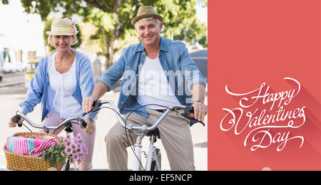 Composite image of happy mature couple going for a bike ride in the city Stock Photo