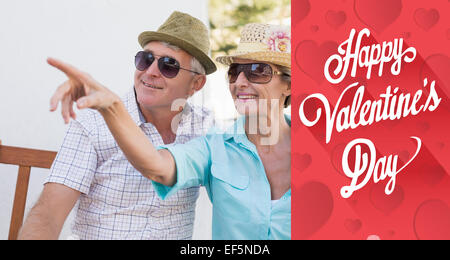 Composite image of happy mature couple sitting on bench in the city Stock Photo