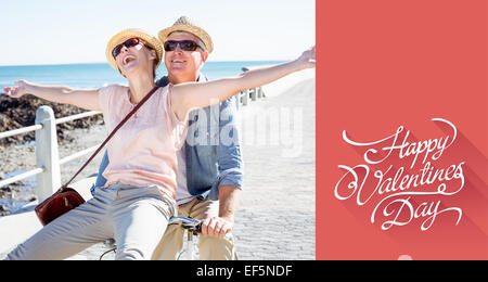 Composite image of happy casual couple going for a bike ride on the pier Stock Photo
