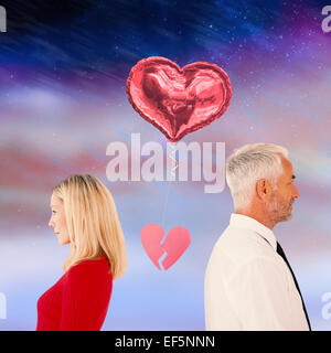 Composite image of couple not talking with broken heart between them Stock Photo