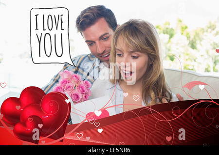 Composite image of loving couple with flowers and greeting card Stock Photo