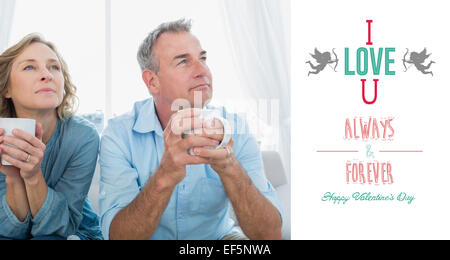 Composite image of thoughtful middle aged couple sitting on the couch having coffee Stock Photo