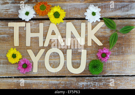 Thank you written with wooden letters and santini flowers Stock Photo