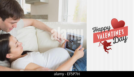 Composite image of prospective parents looking at ultrasound scan on tablet pc Stock Photo