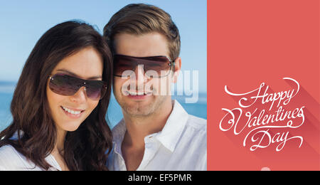 Composite image of smiling couple wearing sunglasses and looking at camera Stock Photo