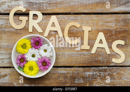 Gracias (which means thank you in Spanish) written with wooden letters and santini flowers Stock Photo