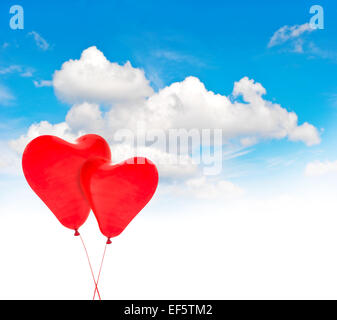 Two heart shaped red air balloons in beautiful blue sky. Valentines Day background Stock Photo