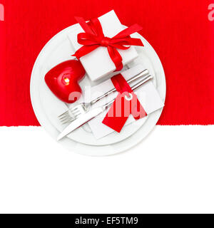 Valentines Day table place setting in Red and White. Festive romantic decoration with candle heart Stock Photo