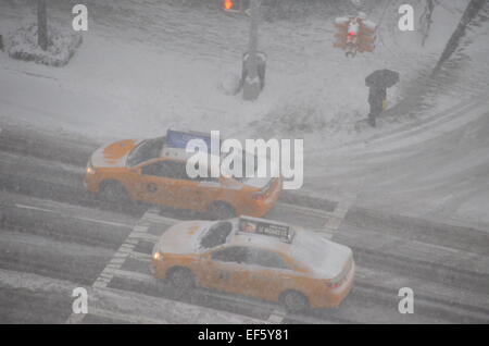 New York, NY, USA. 26th Jan, 2015. Taxis drive through thick snow drifts on the corner of 76th Street and York Avenue in New York, NY, USA, 26 January 2015. A strong snow front has paralysed life in New York and other parts of the east coast of the United States. The snow has slowed down traffic in the city. Photo: Chris Melzer/dpa/Alamy Live News Stock Photo