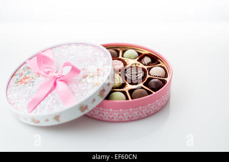 Pink box of chocolates with ribbon on white background Stock Photo