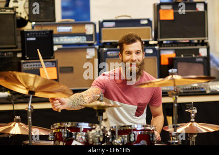 male musician playing cymbals at music store Stock Photo