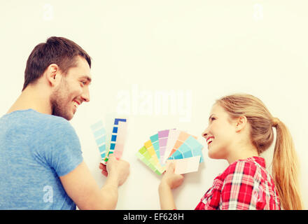 smiling couple looking at color samples at home Stock Photo