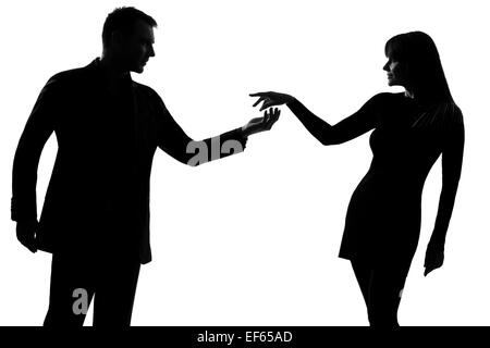 one caucasian couple man holding out inviting hand in hand  woman in studio silhouette isolated on white background Stock Photo