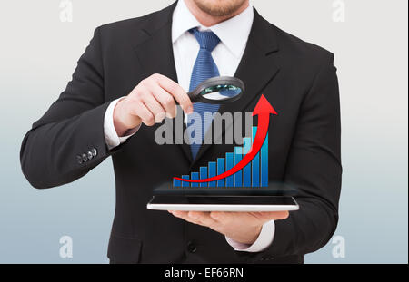 businessman holding magnifier over tablet pc Stock Photo