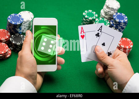 casino player with cards, smartphone and chips Stock Photo