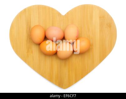 6 brown eggs on a wooden heart shaped background Stock Photo