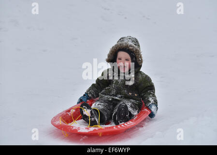 A young boy (2 1/2 yrs) laughing while sledging