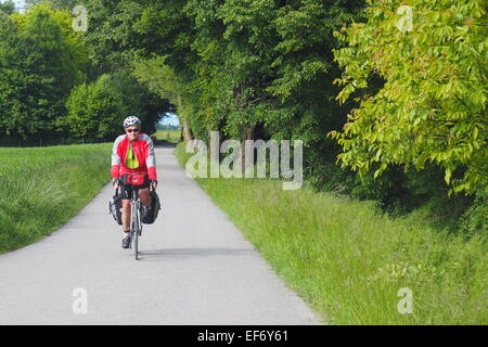 Touring male cyclist riding on a path way in Switzerland. Stock Photo