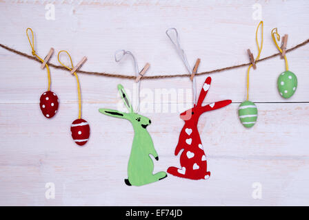 A Couple Of Easter Bunnies One Female And One Red Easter Bunny With Hearts Hanging On A Line With Two Red And Two Green Easter E Stock Photo