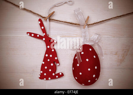A Red Easter Bunny With Hearts And A Big Easter Egg Which Is Dotted And With A Loop And Ribbon Hanging On A Line On White Wooden Stock Photo