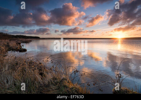 A beautiful dramatic winter sunrise over Crowdy Reservoirnear Davidstow on Bodmin Moor in Cornwall Stock Photo