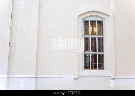 Exterior plaster wall with white window with shutters, showing ...