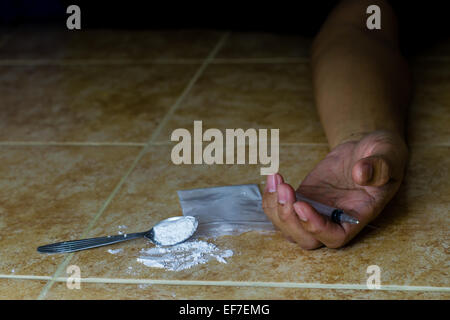 syringe in human hand and cooked heroin Stock Photo